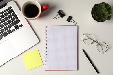 Photo of Notebook, sticky note, pen, floral decor, glasses, coffee and laptop on white table, flat lay