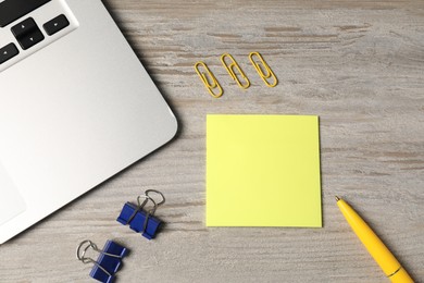 Photo of Different stationery and laptop on wooden table, flat lay