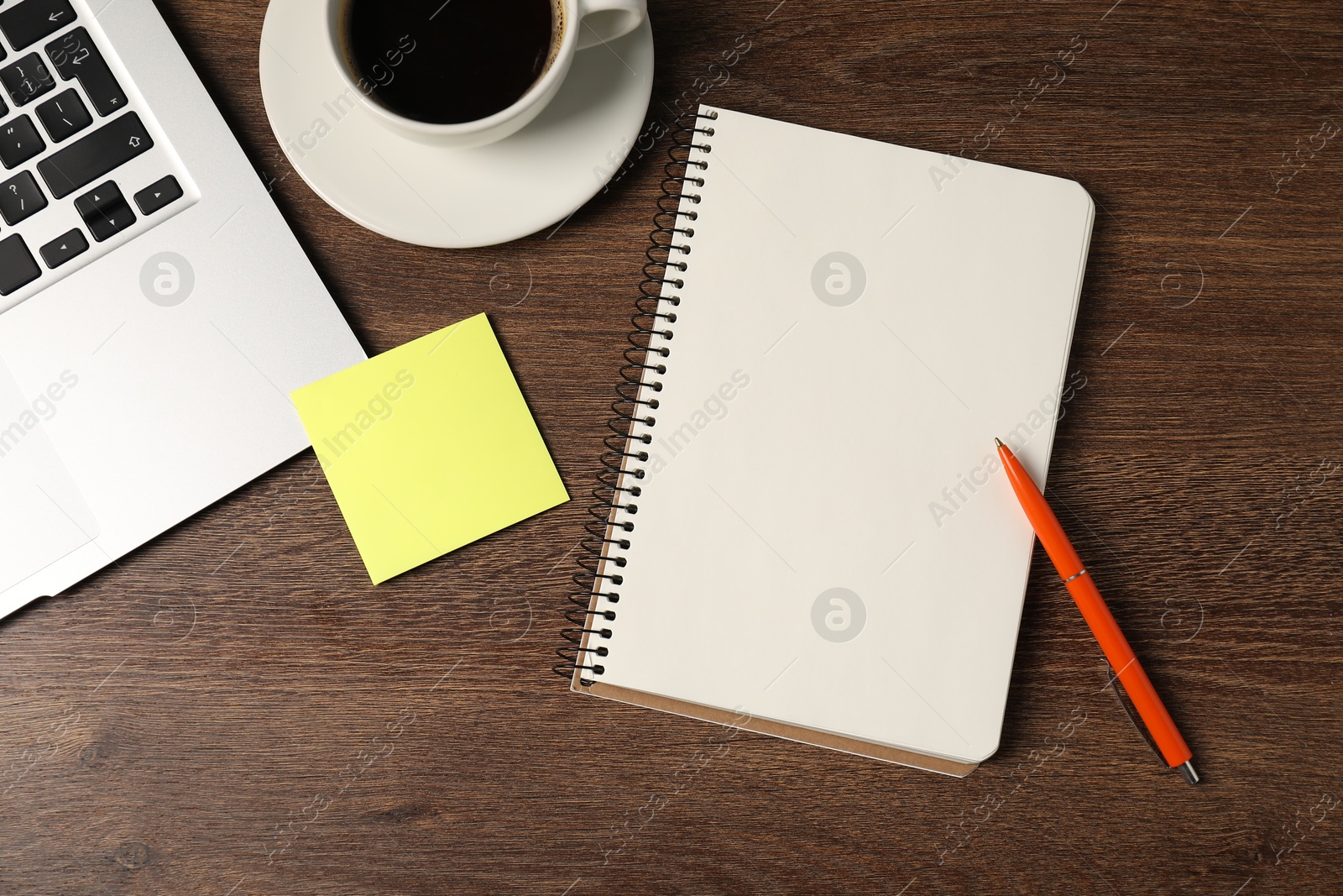 Notebook, pen, sticky note, coffee and laptop on wooden table, flat lay Photo of Notebook, pen, sticky note, coffee and laptop on wooden table, flat lay