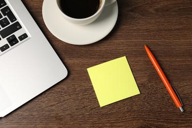 Photo of Sticky note, pen, coffee and laptop on wooden table, flat lay