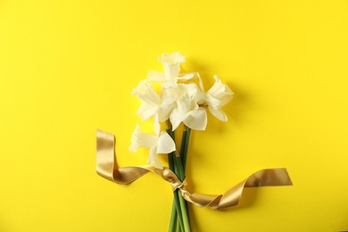 Photo of Bunch of beautiful daffodils on yellow background, top view