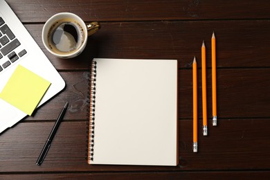 Photo of Notebook, pen, pencils, sticky note, coffee and laptop on wooden table, flat lay