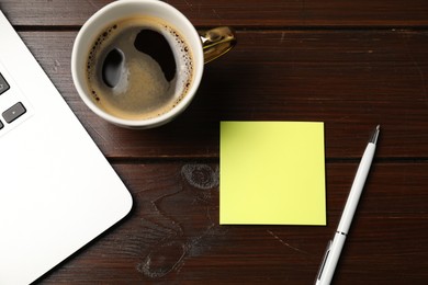 Photo of Sticky note, pen, coffee and laptop on wooden table, flat lay