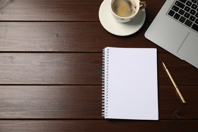 Photo of Notebook, pen, coffee and laptop on wooden table, flat lay. Space for text