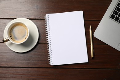 Photo of Notebook, pen, coffee and laptop on wooden table, flat lay