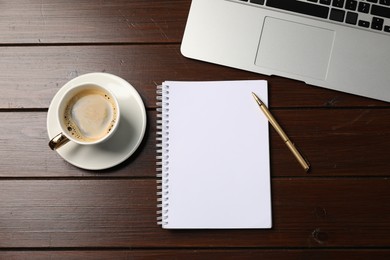 Photo of Notebook, pen, coffee and laptop on wooden table, flat lay
