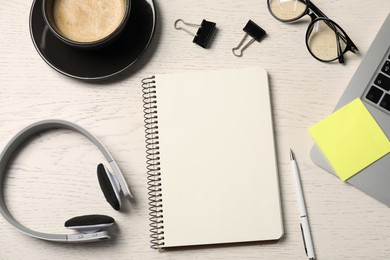 Photo of Notebook, pen, sticky note, glasses, coffee, headphones and laptop on white wooden table, flat lay