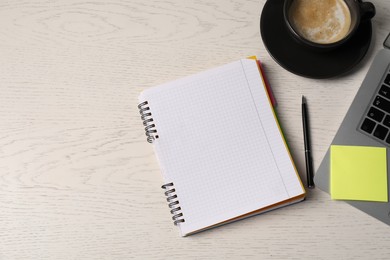 Photo of Notebook, sticky note, pen, coffee and laptop on white wooden table, flat lay. Space for text