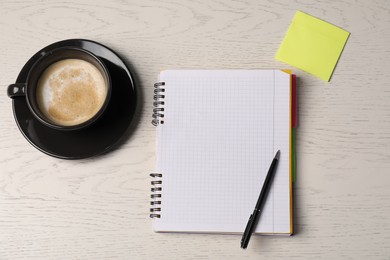 Photo of Notebook, sticky note, pen and coffee on white wooden table, flat lay