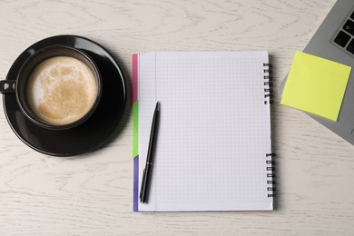 Photo of Notebook, sticky note, pen, coffee and laptop on white wooden table, flat lay