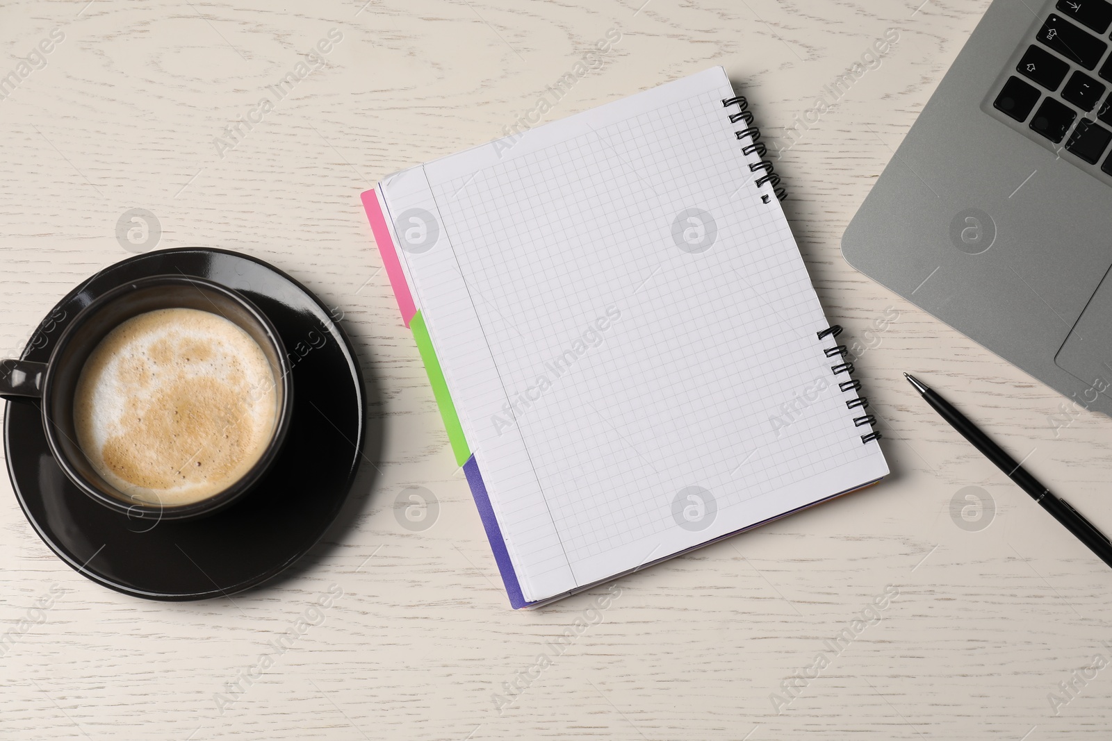 Photo of Notebook, pen, coffee and laptop on white wooden table, flat lay
