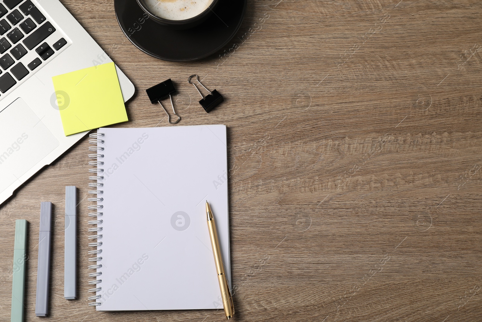 Notebook, other stationery, coffee and laptop on wooden table, flat lay. Space for text Photo of Notebook, other stationery, coffee and laptop on wooden table, flat lay. Space for text
