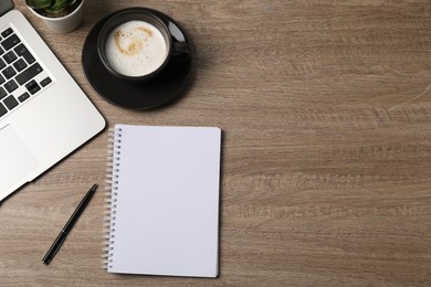Photo of Notebook, pen, coffee and laptop on wooden table, flat lay. Space for text