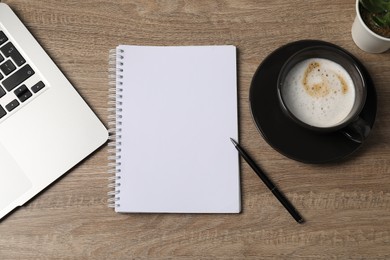 Photo of Notebook, pen, coffee and laptop on wooden table, flat lay