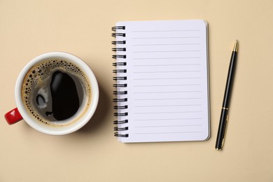 Photo of Notebook, pen and coffee on beige background, flat lay