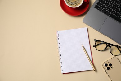 Photo of Notebook, pen, coffee, smartphone, glasses and laptop on beige background, flat lay. Space for text