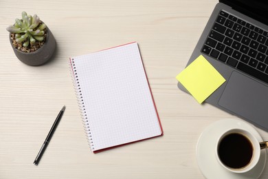 Photo of Notebook, sticky note, pen, coffee, floral decor and laptop on wooden table, flat lay