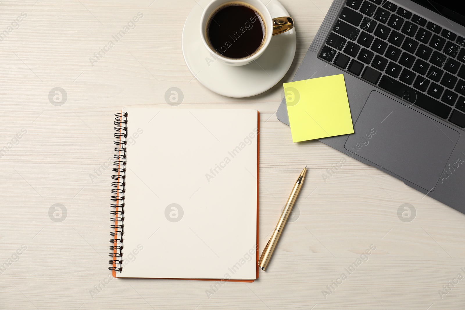 Notebook, pen, sticky note, coffee and laptop on wooden table, flat lay Photo of Notebook, pen, sticky note, coffee and laptop on wooden table, flat lay