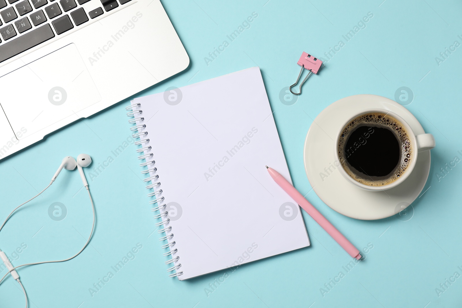 Notebook, pen, earphones, coffee, binder clip and laptop on light blue background, flat lay Photo of Notebook, pen, earphones, coffee, binder clip and laptop on light blue background, flat lay