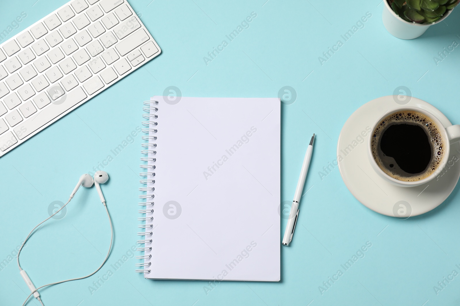 Notebook, pen, earphones, coffee and computer keyboard on light blue background, flat lay Photo of Notebook, pen, earphones, coffee and computer keyboard on light blue background, flat lay