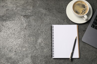 Photo of Notebook, pen, coffee and laptop on grey table, flat lay. Space for text