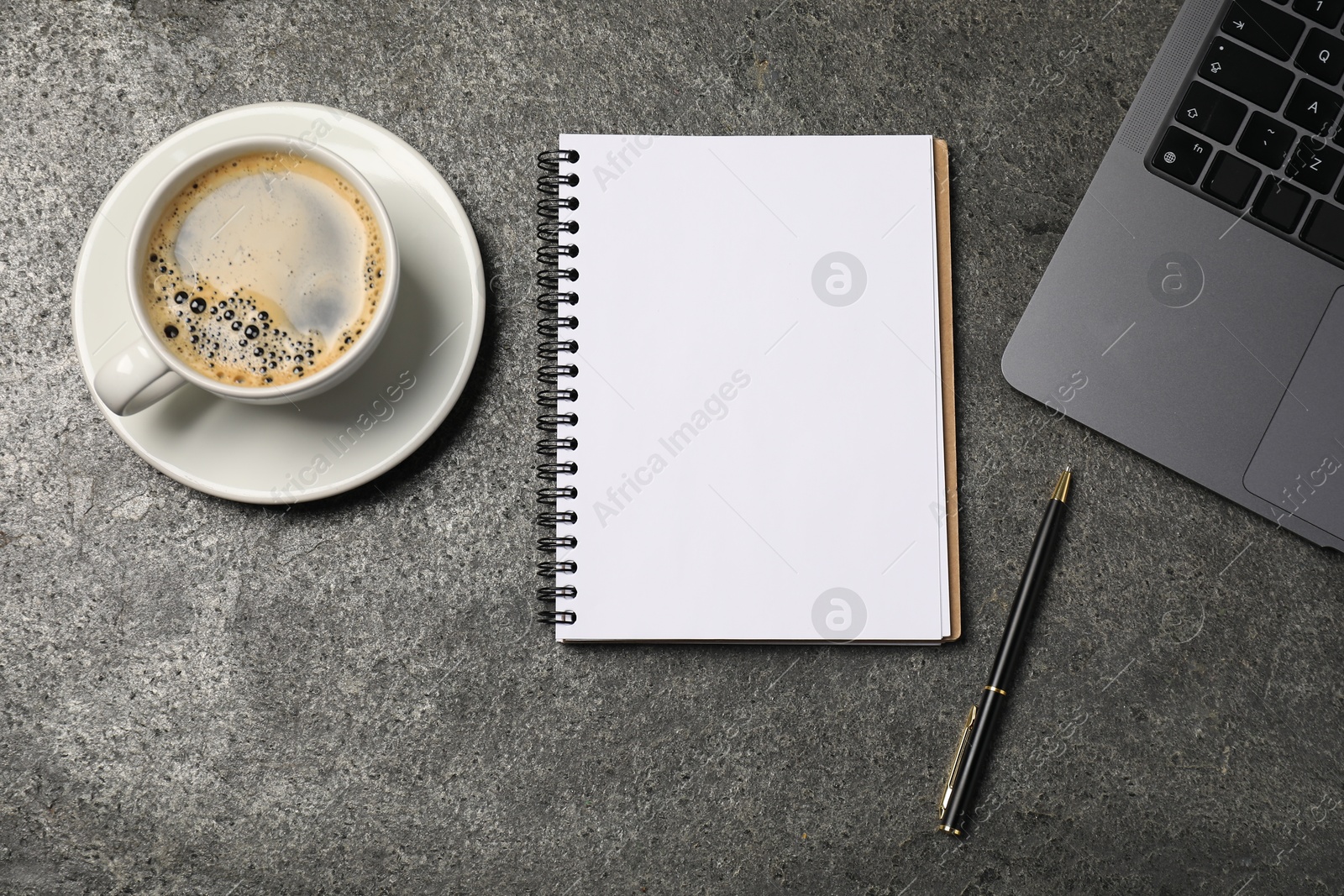 Notebook, pen, coffee and laptop on grey table, flat lay Photo of Notebook, pen, coffee and laptop on grey table, flat lay