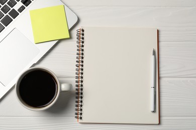 Photo of Notebook, pen, sticky note, coffee and laptop on white wooden table, flat lay