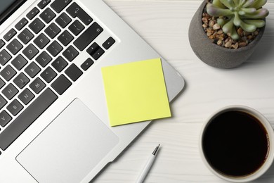 Photo of Sticky note, pen, coffee, floral decor and laptop on white wooden table, flat lay
