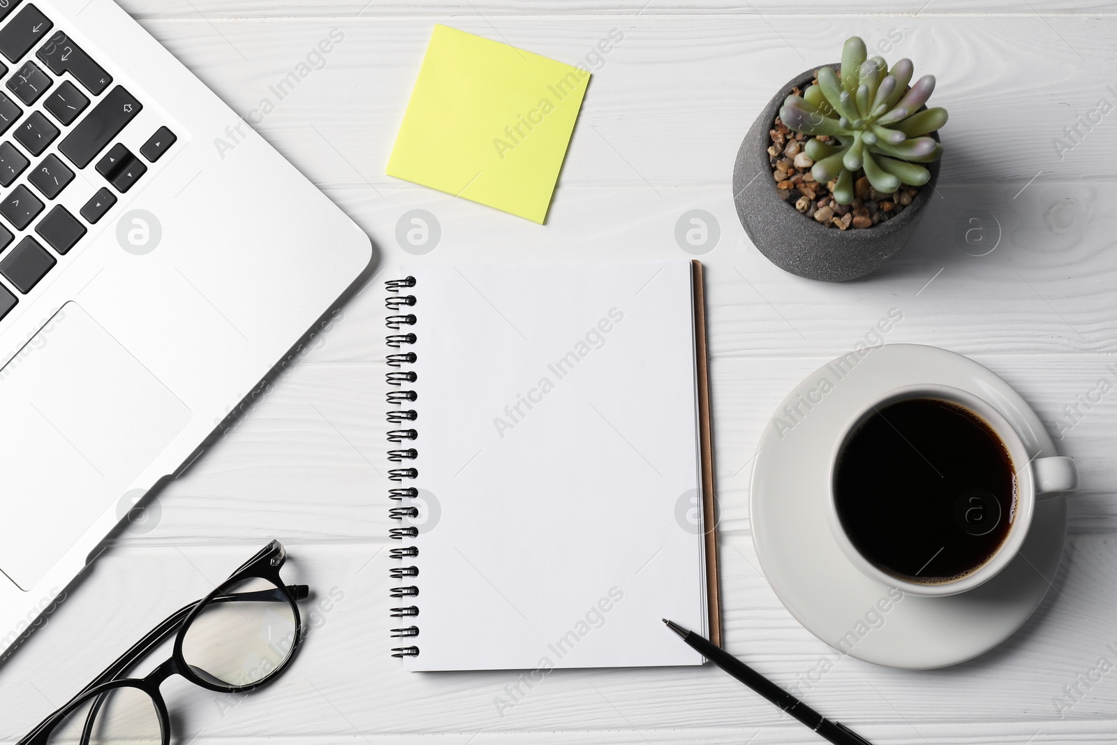 Notebook, pen, sticky note, coffee, glasses, floral decor and laptop on white wooden table, flat lay Photo of Notebook, pen, sticky note, coffee, glasses, floral decor and laptop on white wooden table, flat lay