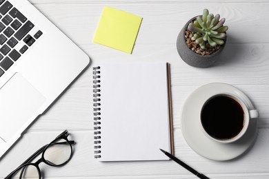 Photo of Notebook, pen, sticky note, coffee, glasses, floral decor and laptop on white wooden table, flat lay