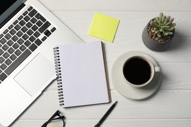 Photo of Notebook, pen, sticky note, coffee, floral decor and laptop on white wooden table, flat lay
