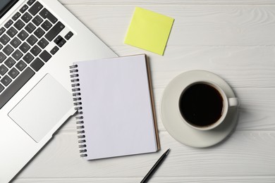 Photo of Notebook, pen, sticky note, coffee and laptop on white wooden table, flat lay