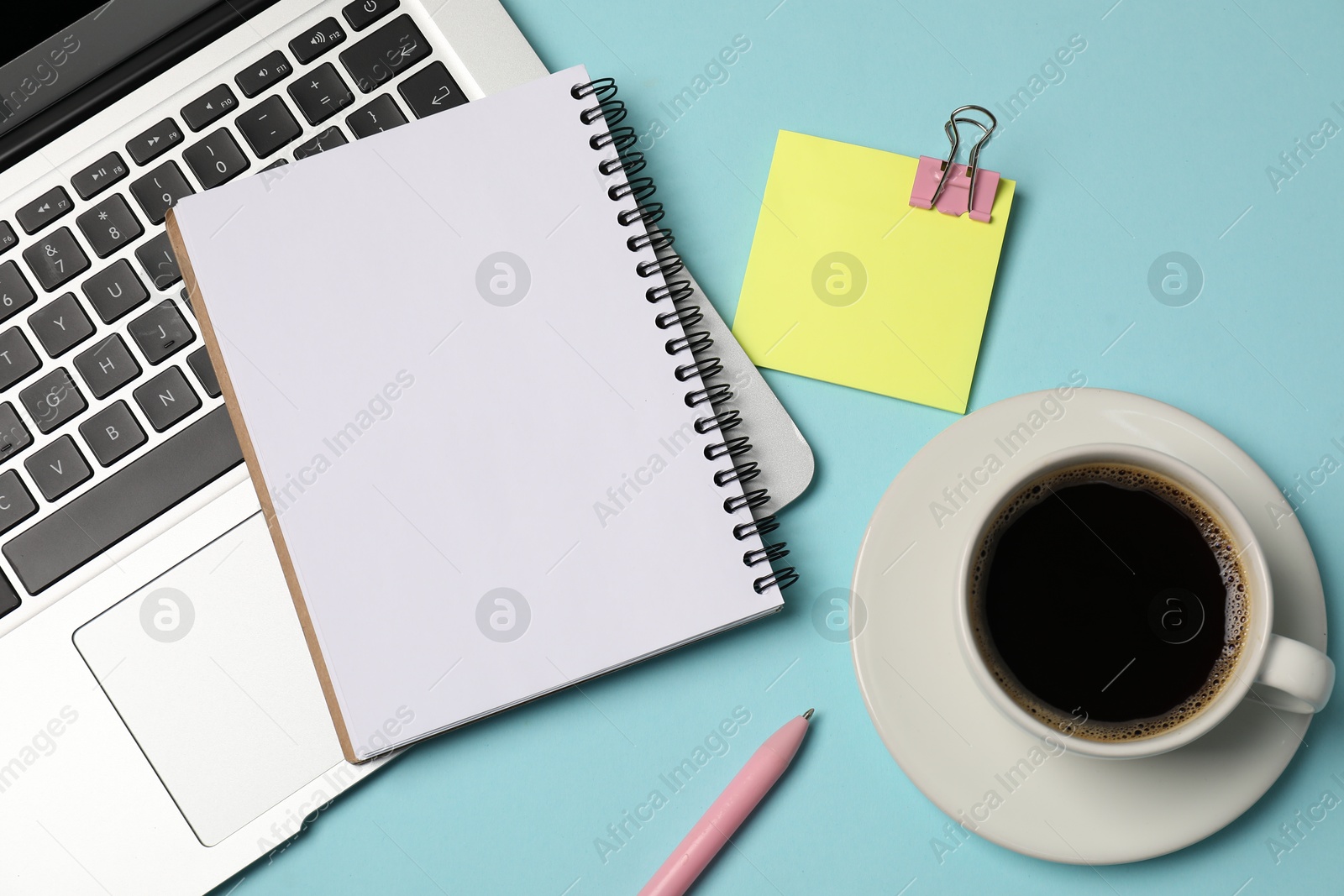 Notebook, sticky note, pen, coffee and laptop on light blue background, flat lay Photo of Notebook, sticky note, pen, coffee and laptop on light blue background, flat lay