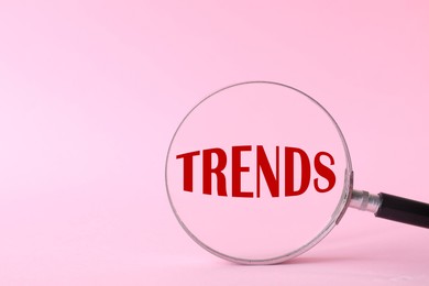 Image of Word Trends, view through magnifying glass on pink background