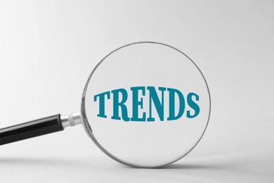 Image of Word Trends, view through magnifying glass on white background
