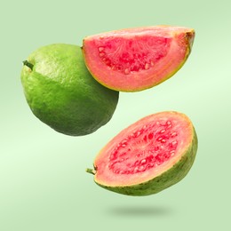 Image of Fresh guava fruits falling on light green background