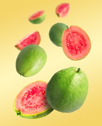 Image of Fresh guava fruits falling on pale orange background