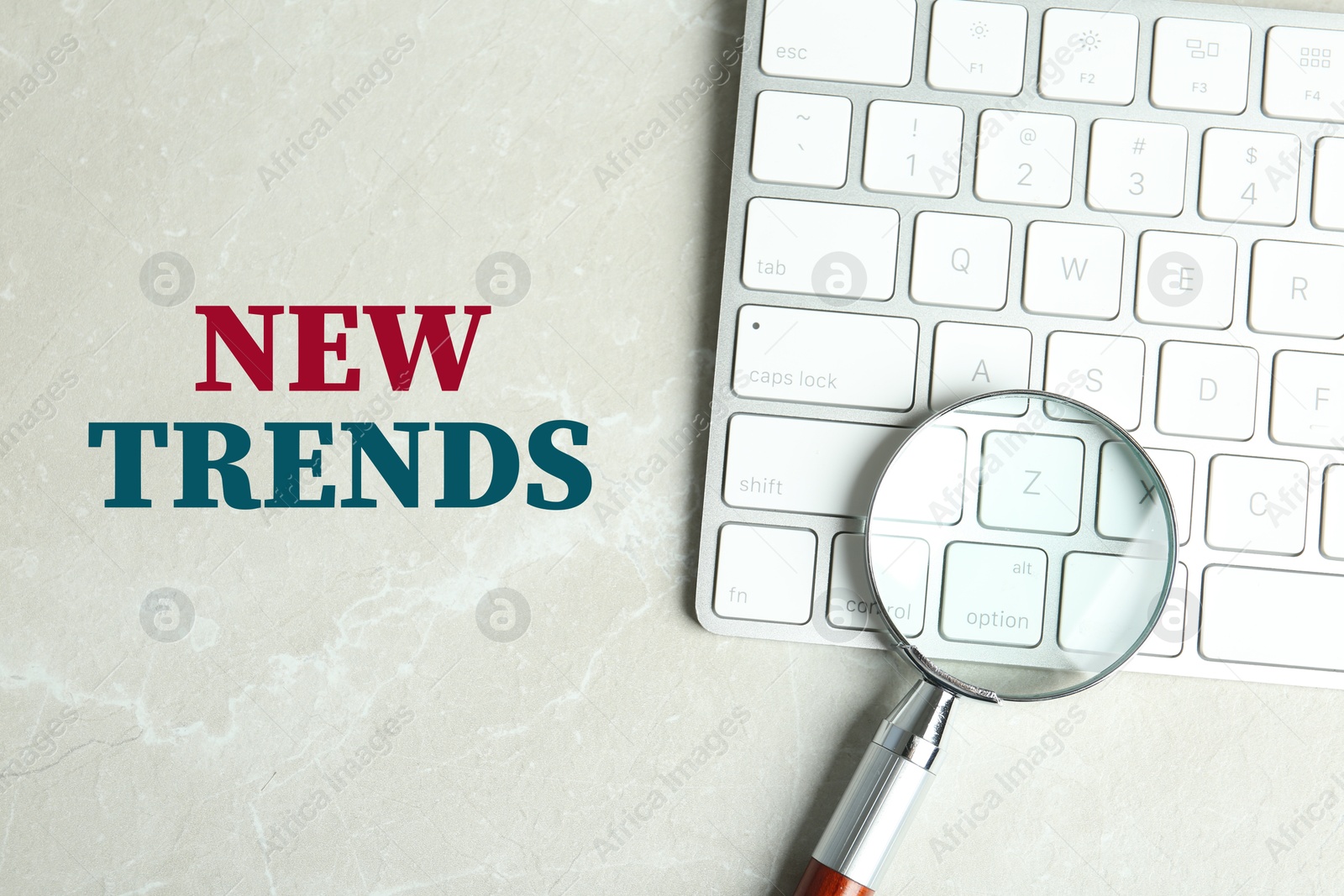 New trends. Magnifying glass and computer keyboard on light table, top view Image of New trends. Magnifying glass and computer keyboard on light table, top view