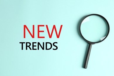 Image of New trends. Magnifying glass on turquoise background, top view