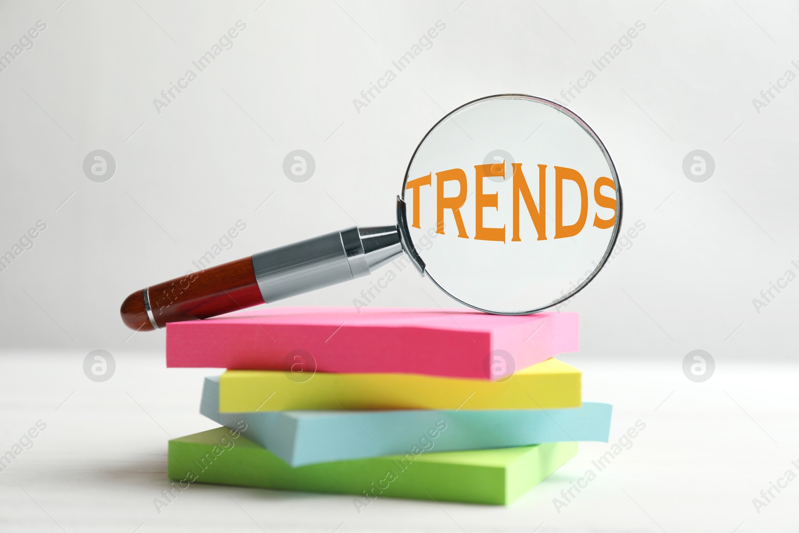 Word Trends in magnifying glass and paper notes on white table Image of Word Trends in magnifying glass and paper notes on white table