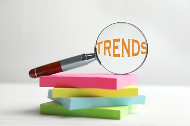 Image of Word Trends in magnifying glass and paper notes on white table