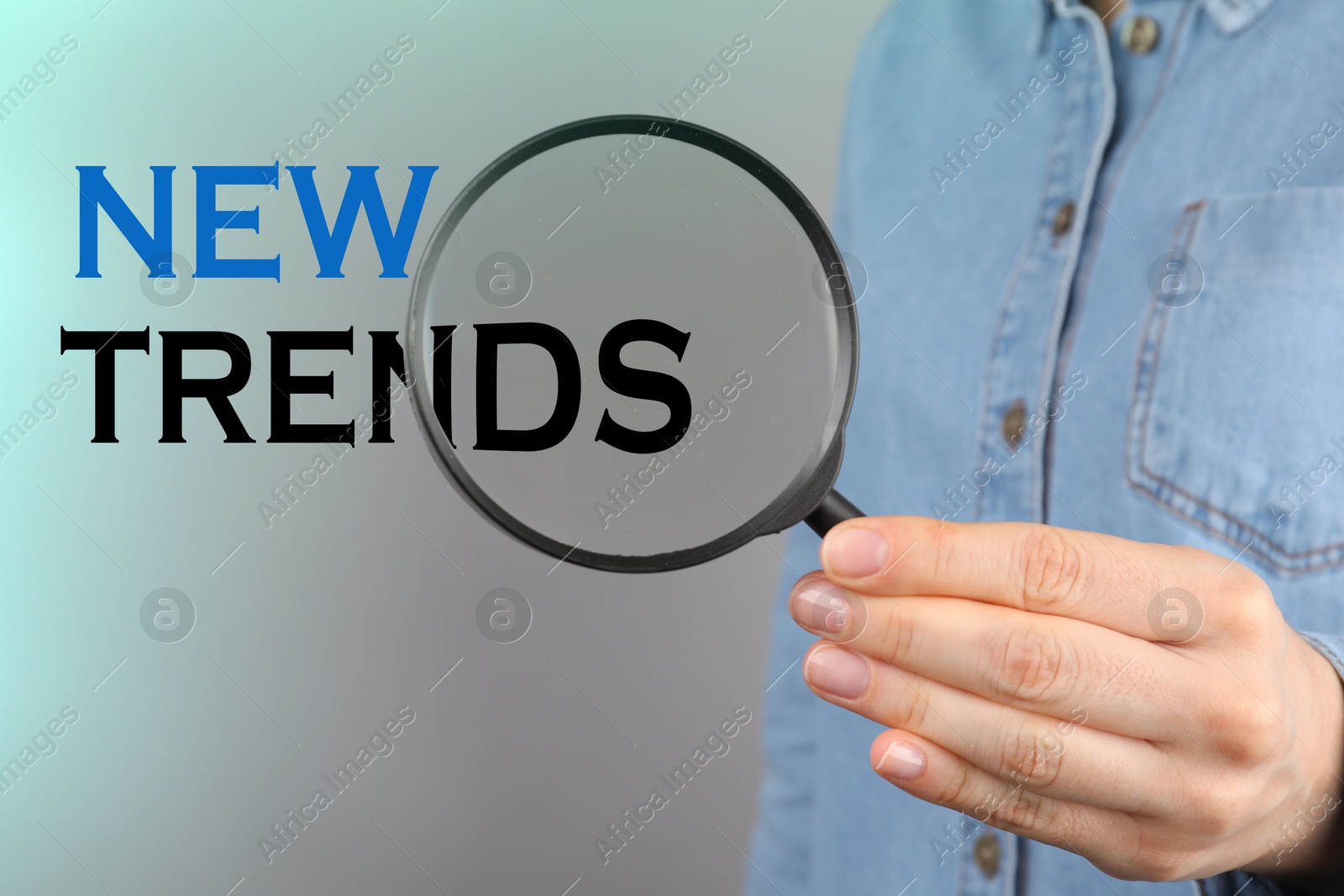 Words New Trends, view through magnifying glass in woman's hand Image of Words New Trends, view through magnifying glass in woman's hand