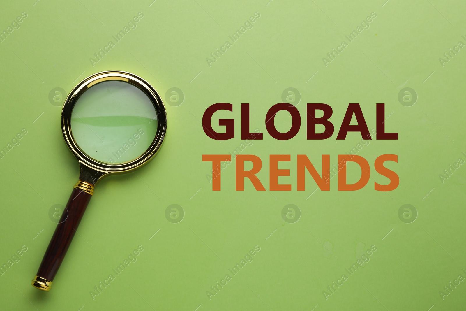 Global trends. Magnifying glass on green background, top view Image of Global trends. Magnifying glass on green background, top view