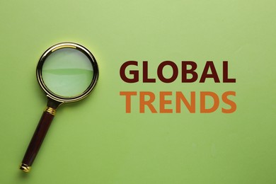 Image of Global trends. Magnifying glass on green background, top view