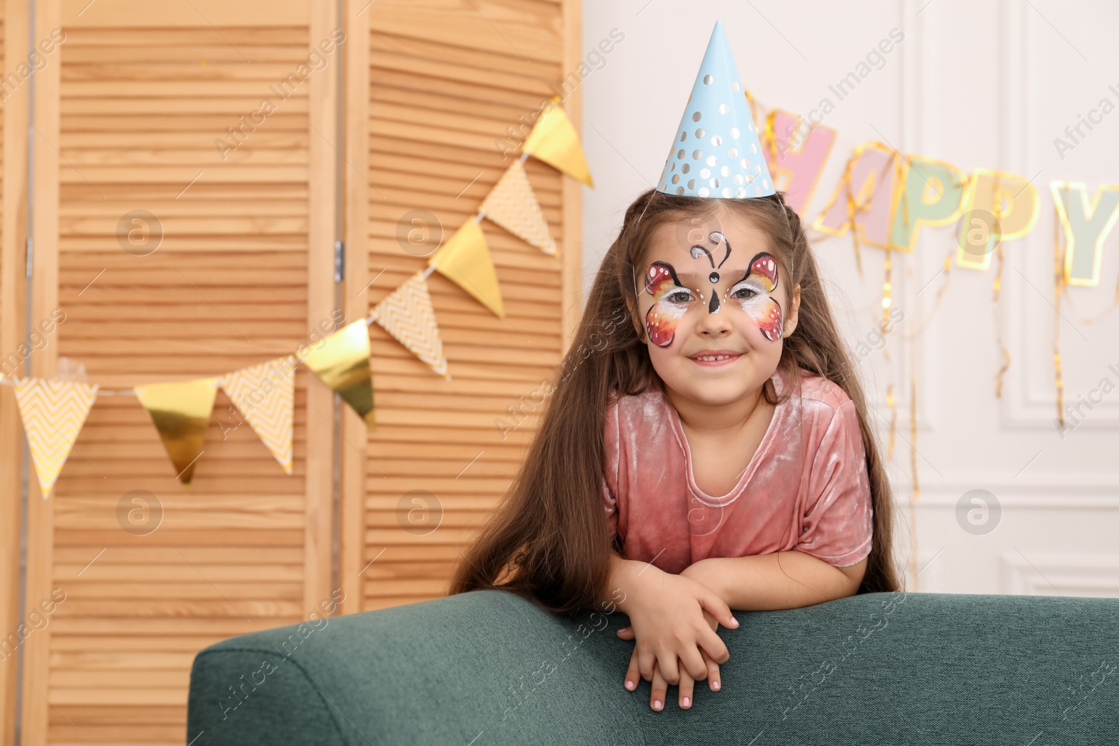 Cute girl with butterfly face painting indoors, space for text Photo of Cute girl with butterfly face painting indoors, space for text