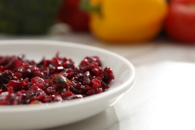 Photo of Cockroach crawling on plate with grated red beets on light table, closeup