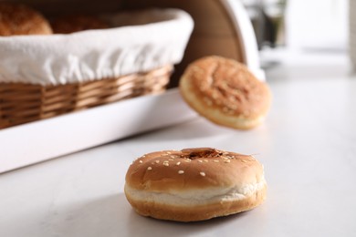 Photo of Cockroach crawling on bun with sesame seeds on light table