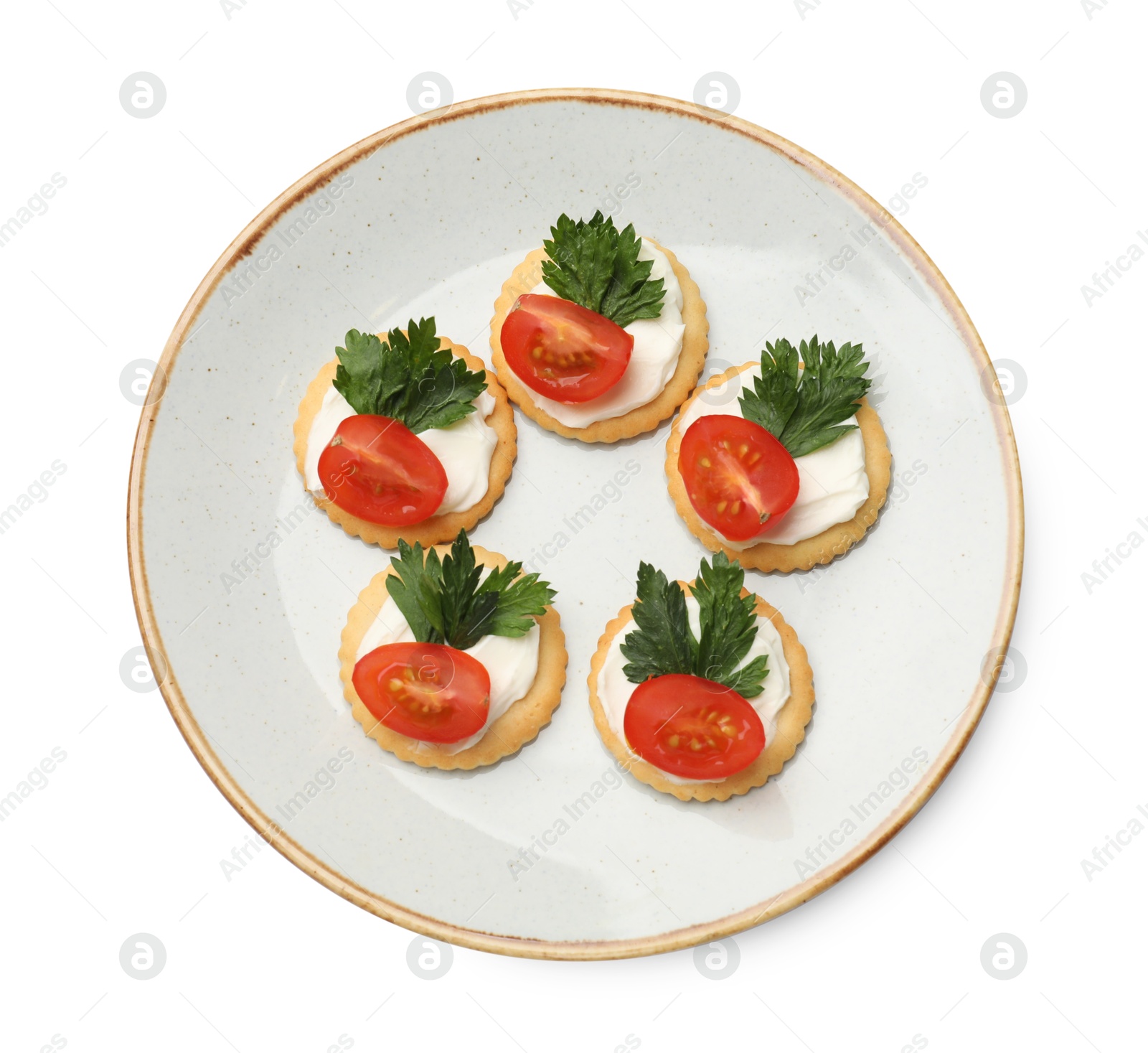 Photo of Tasty crackers with cream cheese, tomatoes and parsley isolated on white, top view