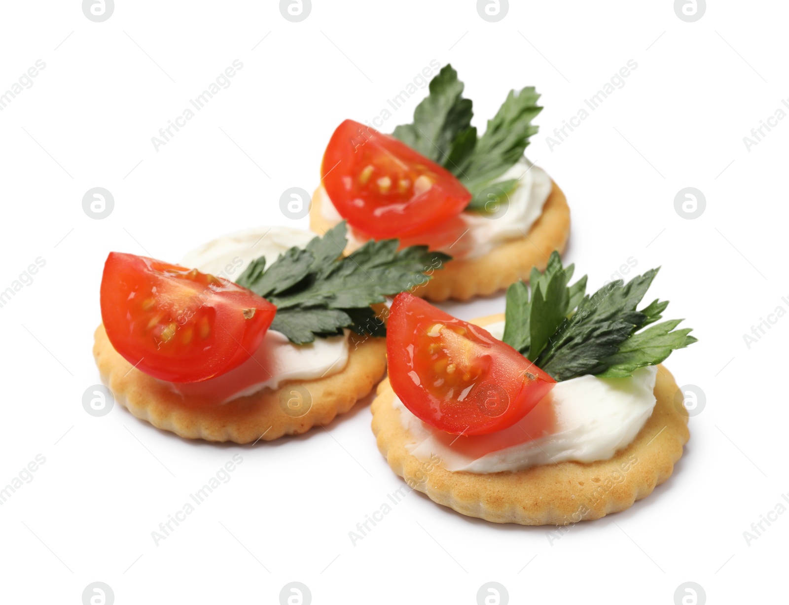 Photo of Tasty crackers with cream cheese, tomatoes and parsley isolated on white