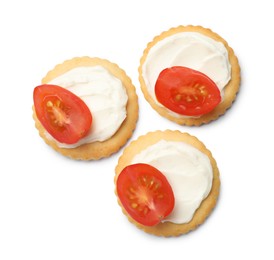 Photo of Tasty crackers with cream cheese and tomatoes isolated on white, top view